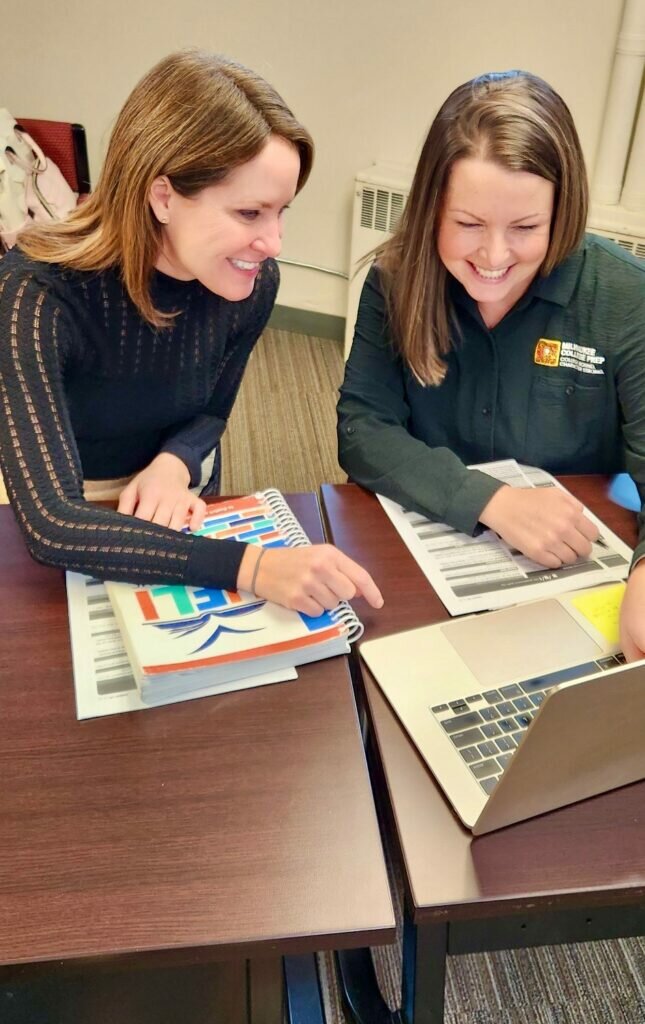 Brittany Kinser and a student staff member smile while reviewing results.